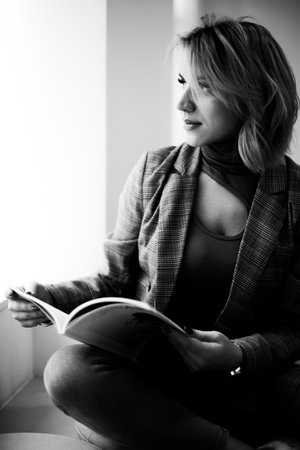 Stylish Woman in Plaid Jacket Relaxing with Magazine - Fashionable Female Enjoying Leisure Time in...