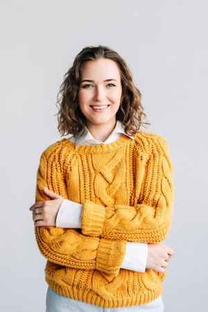 Happy, confident young woman with curly hair smiling at the camera. Isolated against a white...