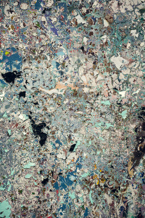 Detailed abstract texture of an aged and weathered surface featuring peeling paint in earthy and...