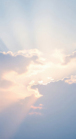 A serene sky with the sun behind clouds, casting gentle rays. This ethereal scene evokes peace, hope, and spirituality. Ideal for backgrounds, inspirational content, or wellness themes.の素材