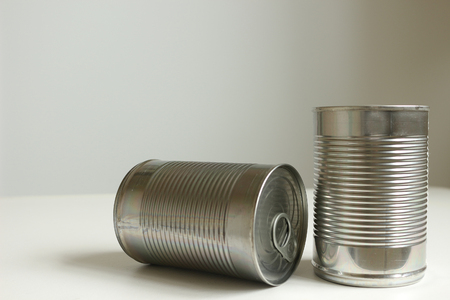 Two tins of canned food againt white background