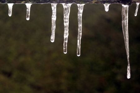 Melting Icicles on the edge of a roofの写真素材