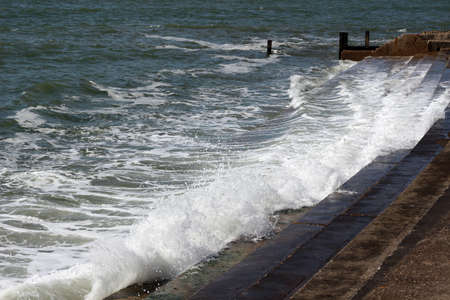 waves crashing on the seawallの写真素材