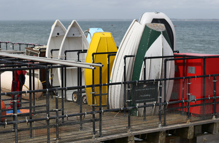 dinghies stored vertically in racks by the seaの写真素材