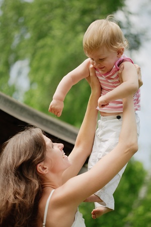 Mother throws baby up. Boy laughsの写真素材