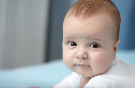 A four-month baby looks into the camera. Close-up