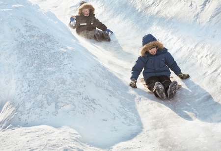 Kids slip on the snowy slope. Winterの写真素材
