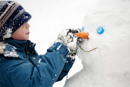 The boy sculpts snowman. Winter, outdoors, close-upの写真素材