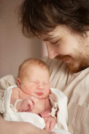 Man holds in his arms newborn daughterの写真素材