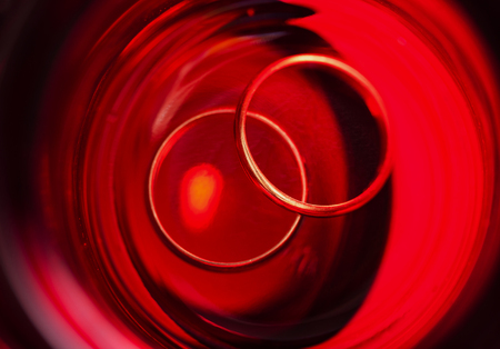 Two gold rings on red background. Close-up.の写真素材