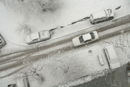 Roads, lawns, cars and trees covered with snow. View from aboveの写真素材