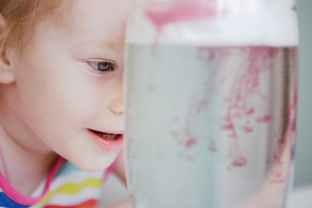 little girl watches through a layer of foam shaving paint seepsの写真素材