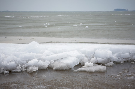 pieces of ice are on the beach. Early spring
