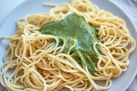 on white plate is noodles with green sauceの写真素材