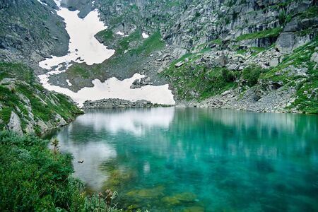 Turquoise water of the alpine lake. Glacier at the foot of the mountain.の写真素材