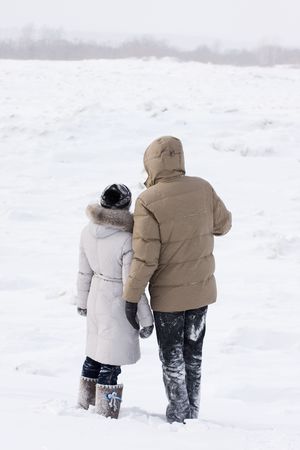 loving couple on the shore of frozen riverの写真素材