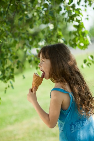 girl eating ice cream and looking awayの写真素材