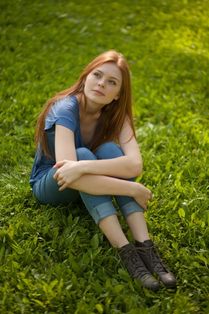 beautiful girl sitting on grassの写真素材