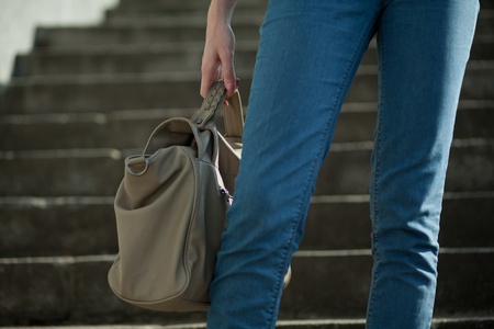 feet girl holding a bag on the stairsの写真素材