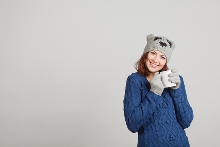 girl in blue with a mug of tea trying to warm