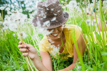 young girl among dandelions summer dayの写真素材
