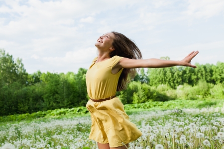 young girl among dandelions summer dayの写真素材