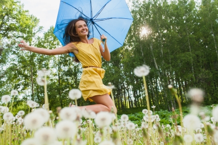 young girl among dandelions summer dayの写真素材