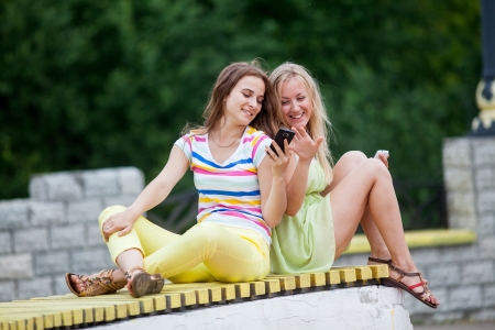 Girl on a bench with phonesの写真素材