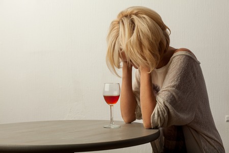 Girl sitting at a table with a wine glassの写真素材