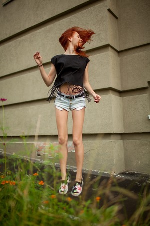 Young beautiful woman jumping waving hairの写真素材