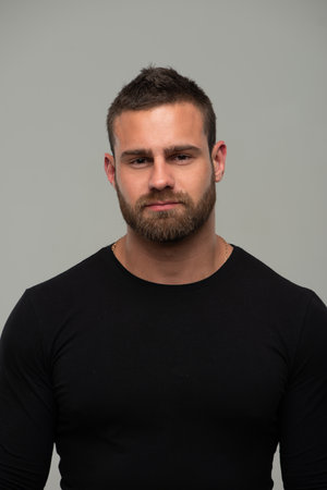 Portrait of handsome bearded man in black t-shirt against gray backgroundの写真素材