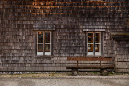 old wooden facade house exterior with park benchの写真素材