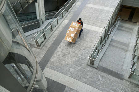 Milan, street scene in Porta Nuova district - aerial view of a delivery man wearing a mask protectionのeditorial素材