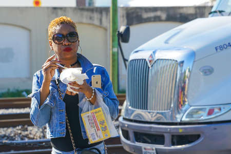 New Orleans - 04/15/2018: black woman with short dyed hair eating outdoorのeditorial素材