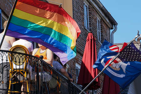 New Orleans - 04/15/2018: people enjoying drinks on a cafe balcony under the LGBT flagのeditorial素材