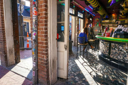 New Orleans - 04/15/2018: girl sitting in interior of a barのeditorial素材