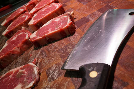 Higgins family butcher, rib eye on the chopping board with cleaverのeditorial素材
