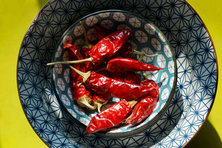 Mortara 09/15/2020: dried red chili peppers in a Japanese style bowl and pea green dishの写真素材
