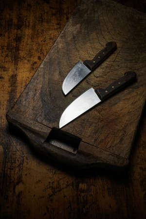 Mortara 09/10/2019: two kitchen knives on wooden cutting boardの写真素材