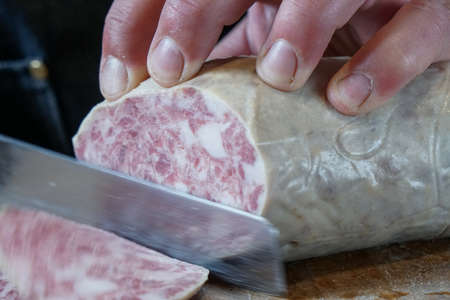 slicing the goose salamiの写真素材