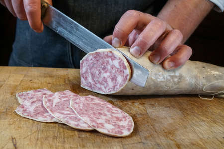 Mortara 04/05/2019: slicing the goose salamiの写真素材