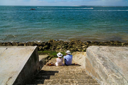 La Teste-de-Buch - 08/25/2020: couple sitting on the steps looking at the seaのeditorial素材