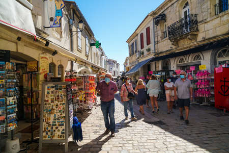 Saintes Maries de la Mer - 09/04/2020: people with mask protections walk in the street among souvenirs shopsのeditorial素材