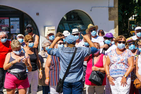 Saintes Maries de la Mer - 09/04/2020: tourists wearing mask protection listening to a guideのeditorial素材