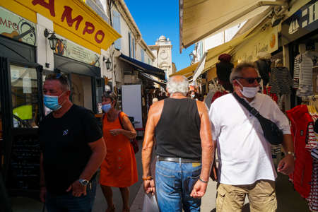Saintes Maries de la Mer - 09/04/2020: a man walks upstream in the crowdのeditorial素材
