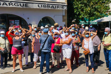 Saintes Maries de la Mer - 09/04/2020: Saintes Maries de la Mer - 09/04/2020: tourists wearing mask protection listening to a guideのeditorial素材