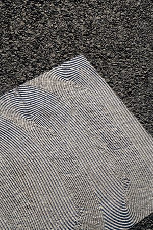Close-up of a black asphalt surface with a pattern of lines.の写真素材