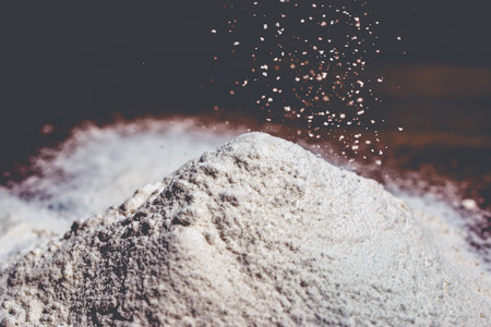 Flour rain on a mount of wheat flour to create it.の写真素材