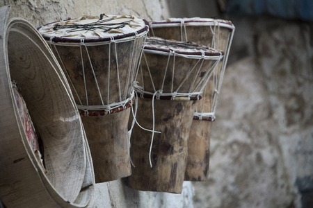 Essaouria, Morocco - September 2017: African drums(Djembe) and drum frame hung on wall outside of craftsman's workshopのeditorial素材