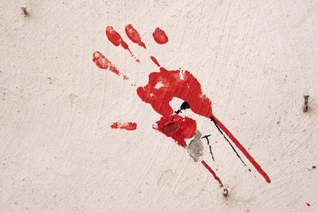Hand print in red paint on a white wallの写真素材